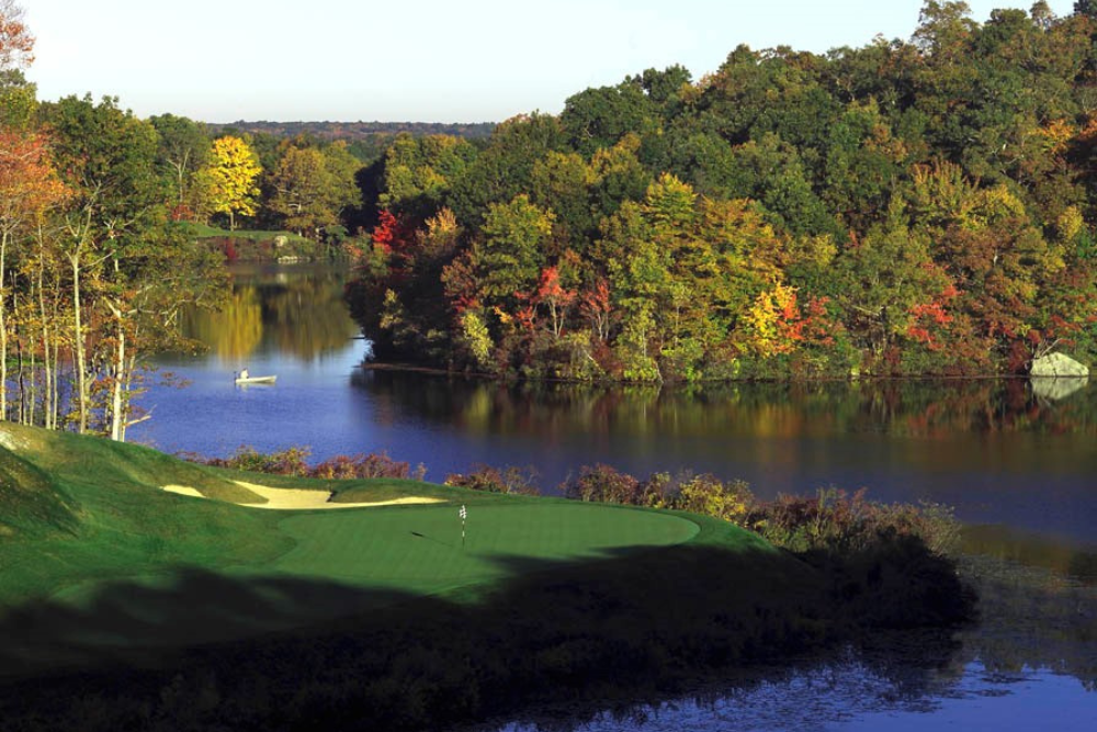 Lake of Isles Golf Course greens as they meet a body of water. Across the water, trees changing colors.